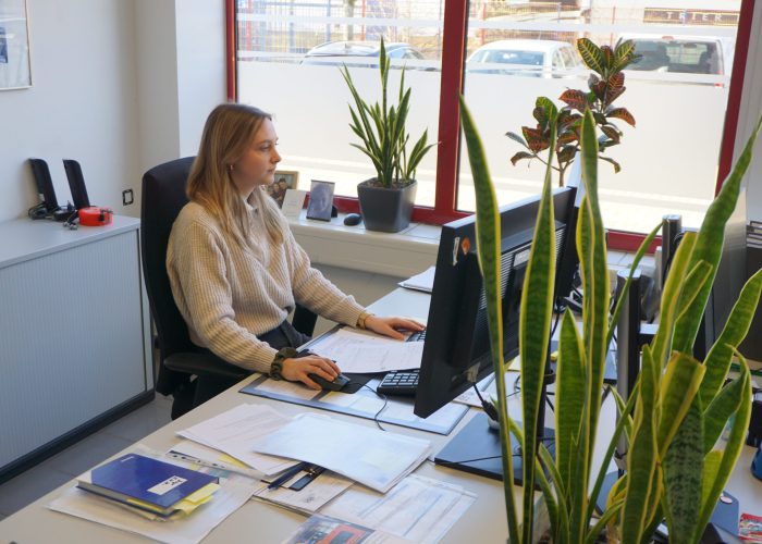 Mitarbeiterin von sbt Trier bearbeitet Unterlagen am PC im Büro
